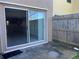 Covered patio with sliding glass doors leading into a kitchen and wood privacy fence at 1512 Chateaux De Ville Ct, Clearwater, FL 33764