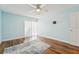 Light bedroom with ceiling fan, wood-look floors, and a sliding door at 1515 12Th Se Ct # 55, Largo, FL 33771