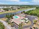 Aerial view of a community center featuring pool, tennis courts, parking, and lush green surroundings at 1515 12Th Se Ct # 55, Largo, FL 33771