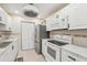 Updated kitchen with white appliances, tile backsplash, and ample cabinet space at 1515 12Th Se Ct # 55, Largo, FL 33771