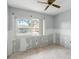 A bedroom featuring tile floors, a ceiling fan, and a window showcasing the exterior surroundings at 1671 Cape Ann Ne Ave # 4, St Petersburg, FL 33702