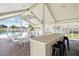 An outdoor eating area near a pool has multiple tables, chairs, and stools at 1671 Cape Ann Ne Ave # 4, St Petersburg, FL 33702