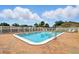 Fenced community pool and lounge chairs with sunny skies, perfect for relaxing by the water at 1671 Cape Ann Ne Ave # 4, St Petersburg, FL 33702