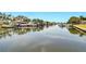 Waterfront view with multiple boats docked along the canal, surrounded by lush greenery and vibrant landscaping at 1671 Cape Ann Ne Ave # 4, St Petersburg, FL 33702