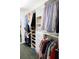 Spacious walk-in closet with custom shelving, drawers, hanging rods and carpeted floors at 17734 Long Ridge Rd, Tampa, FL 33647