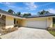Exterior with a two-car garage and solar panels on the roof at 18426 Sterling Silver Cir, Lutz, FL 33549