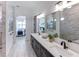 Spacious bathroom with double vanity and view to bedroom with chandelier and en-suite bathroom with walk-in shower at 1845 Ridgemore St, North Port, FL 34289