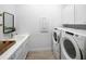 Clean, bright laundry room with white cabinets, sink, and modern washer and dryer at 1845 Ridgemore St, North Port, FL 34289