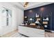 Well-lit home office with custom shelving, modern desk, and large window for natural light at 1845 Ridgemore St, North Port, FL 34289