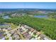 An aerial view of a cozy neighborhood bordering a lush forest and a tranquil pond, offering a blend of comfort and nature at 2321 Wood Pointe Dr, Holiday, FL 34691