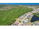 Aerial view of a residential community bordering a lush green forest and a serene pond at 2321 Wood Pointe Dr, Holiday, FL 34691