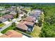Aerial view of a neighborhood with backyard pools, mature trees, and a view of a small pond at 2321 Wood Pointe Dr, Holiday, FL 34691