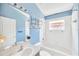 Bathroom with blue walls, shower/tub combo, white fixtures, and a vanity with sink at 2321 Wood Pointe Dr, Holiday, FL 34691