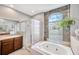 Bathroom featuring a sunken tub, tiled floors, a walk-in shower and a large window with views of the outside at 2321 Wood Pointe Dr, Holiday, FL 34691