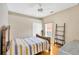 Bedroom with hardwood floors, ceiling fan, window, ladder shelf, and a bed with striped yellow and blue bedding at 2321 Wood Pointe Dr, Holiday, FL 34691