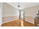 Bedroom with hardwood floors, ceiling fan, window with curtains and view of the outside, and white-beige colored walls at 2321 Wood Pointe Dr, Holiday, FL 34691