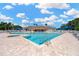 Large community pool area with plenty of lounge chairs for residents to enjoy under sunny skies at 2321 Wood Pointe Dr, Holiday, FL 34691