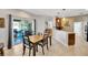 Open dining area with sliding door access to outdoor patio and a view of the kitchen bar at 2321 Wood Pointe Dr, Holiday, FL 34691