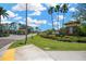 Community entrance with Key Vista signage, palm trees, and well-maintained landscaping under a partly cloudy sky at 2321 Wood Pointe Dr, Holiday, FL 34691