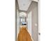 Hallway with hardwood floors leads to a main bedroom with sliding glass doors and a ceiling fan at 2321 Wood Pointe Dr, Holiday, FL 34691