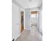 Hallway with tile floors leads to a carpeted bedroom and tiled bathroom at 2321 Wood Pointe Dr, Holiday, FL 34691