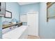Bright laundry room with blue walls, modern washer and dryer set, and built-in shelving at 2321 Wood Pointe Dr, Holiday, FL 34691