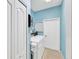 Modern laundry room with blue walls, new washer and dryer set, and ample storage space at 2321 Wood Pointe Dr, Holiday, FL 34691