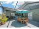Inviting screened patio featuring an umbrella-covered table and a comfortable hammock at 2321 Wood Pointe Dr, Holiday, FL 34691