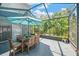 Outdoor patio with table seating, an umbrella, string lights and a view of lush greenery at 2321 Wood Pointe Dr, Holiday, FL 34691