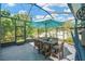 Spacious screened patio with dining and lounging areas, featuring comfortable seating and dining options at 2321 Wood Pointe Dr, Holiday, FL 34691