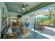 Relaxing screened patio with both dining and living space, furnished with an umbrella-covered table and hammock at 2321 Wood Pointe Dr, Holiday, FL 34691