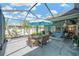 Inviting screened patio featuring dining and lounging areas, complete with hammock and lush scenery at 2321 Wood Pointe Dr, Holiday, FL 34691