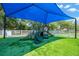 Community playground area with a colorful play structure, soft turf, and a shaded canopy at 2321 Wood Pointe Dr, Holiday, FL 34691