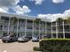 Condo building with decorative architectural pillars and white railings with ample parking and blue sky at 2450 Canadian Way # 6, Clearwater, FL 33763