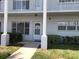 Inviting condo unit with a well-maintained lawn, walkway, and ample natural light from large windows at 2450 Canadian Way # 6, Clearwater, FL 33763