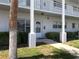 Exterior view of condo with white pillars, walkway, and lush landscaping at 2450 Canadian Way # 6, Clearwater, FL 33763