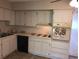 Standard kitchen layout featuring white cabinets, essential appliances, and tile floors at 2450 Canadian Way # 6, Clearwater, FL 33763