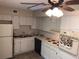 Classic kitchen with all-white cabinetry, essential appliances, and tiled floors at 2450 Canadian Way # 6, Clearwater, FL 33763
