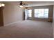 Spacious living room featuring neutral carpet, a ceiling fan, and lots of natural light from the many windows at 2450 Canadian Way # 6, Clearwater, FL 33763