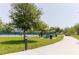 Scenic view of a community park featuring picnic tables and a walking path by tennis courts at 2457 Ecuadorian Way # 63, Clearwater, FL 33763