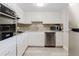Modern kitchen features white cabinets, stainless steel appliances, and decorative backsplash at 2457 Ecuadorian Way # 63, Clearwater, FL 33763