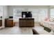 Sunlit living room with whitewashed flooring, large windows, and furnishings at 2457 Ecuadorian Way # 63, Clearwater, FL 33763
