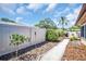 A landscaped backyard featuring a walkway, privacy fence, lush plants, and an inviting outdoor living space at 2597 Bramblewood E Dr, Clearwater, FL 33763