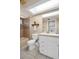 Neutral bathroom featuring a toilet, vanity with sink, tiled shower-tub combination, and a decorative mirror at 2597 Bramblewood E Dr, Clearwater, FL 33763