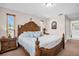 This spacious bedroom features a beautifully carved bed frame, a neutral color scheme, and natural light from nearby windows at 2597 Bramblewood E Dr, Clearwater, FL 33763