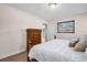 Bright bedroom with a queen bed, a wooden dresser, a window providing ample natural light, and neutral-colored walls at 2597 Bramblewood E Dr, Clearwater, FL 33763