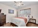 Relaxing bedroom with a queen bed, wooden accents, and a window overlooking the neighborhood at 2597 Bramblewood E Dr, Clearwater, FL 33763