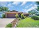 Charming single-story home with a well-maintained lawn, mature landscaping, and a two-car garage at 2597 Bramblewood E Dr, Clearwater, FL 33763
