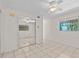 Bright bedroom with tile flooring, mirrored closet, and a ceiling fan at 273 Shore Dr, Palm Harbor, FL 34683