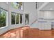 Sunlit living room featuring hardwood floors, large windows, and modern cabinets at 273 Shore Dr, Palm Harbor, FL 34683